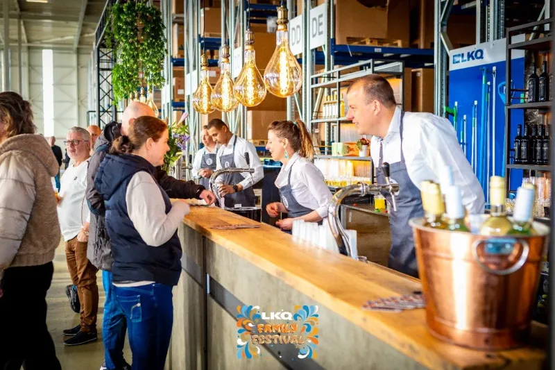 Barpersoneel achter een houten eventbar