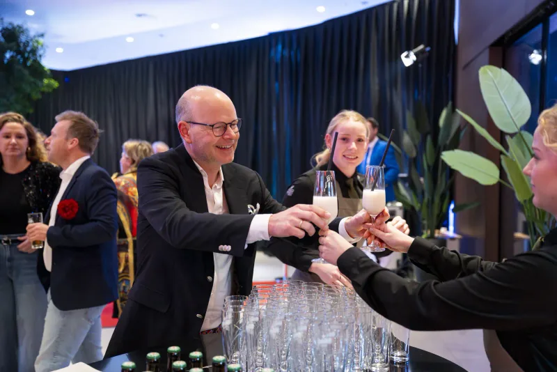 Welkomstdrankjes worden uitgedeeld aan gasten